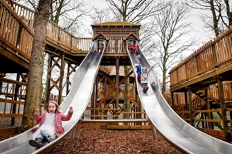 Two Single Big Slides, With Two Children With Smiling Faces At Fort Douglass Adventure Park